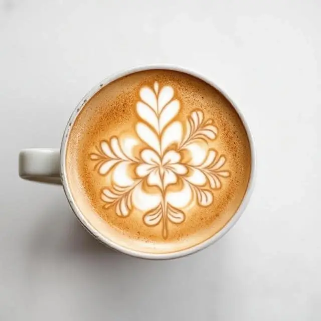 Intricate latte art in a ceramic cup.